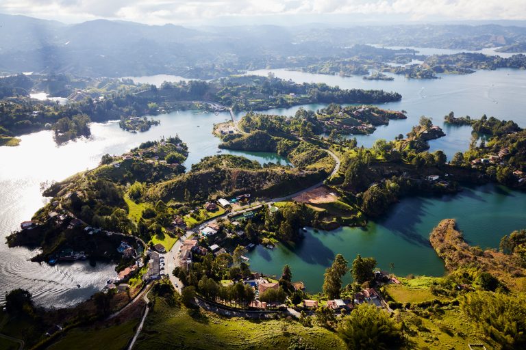 An aerial shot of the Guatape town in Columbia with mountains and clouded sky in the background